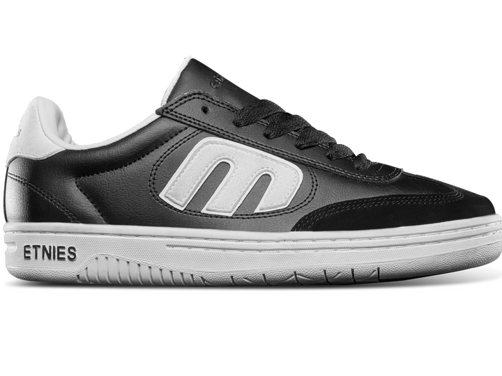 etnies Lowcut Shoe in black and white with triple “E” logo, suede and mesh upper, exposed EVA midsole, and heritage gum outsole.