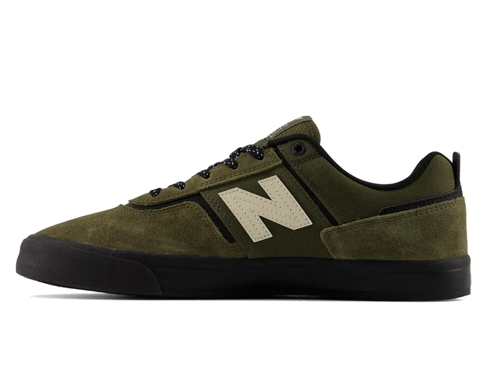 An olive green New Balance sneaker with a black sole and laces, featuring the signature beige 'N' logo on the side, shown against a plain white background.