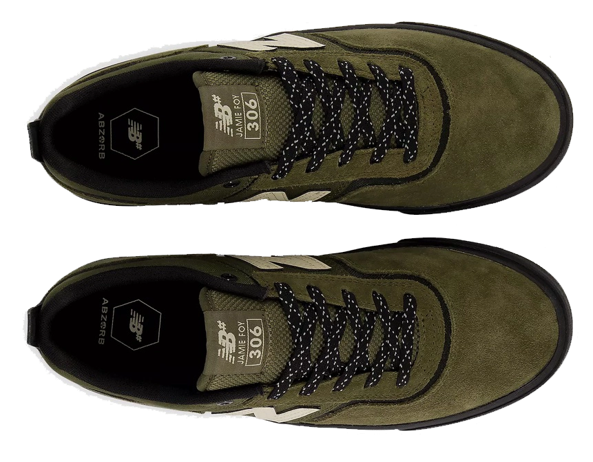 A pair of New Balance 906 low-top sneakers in olive green suede and mesh, featuring black speckled laces, black soles, and beige side stripes, shown from a top-down view on a white background.