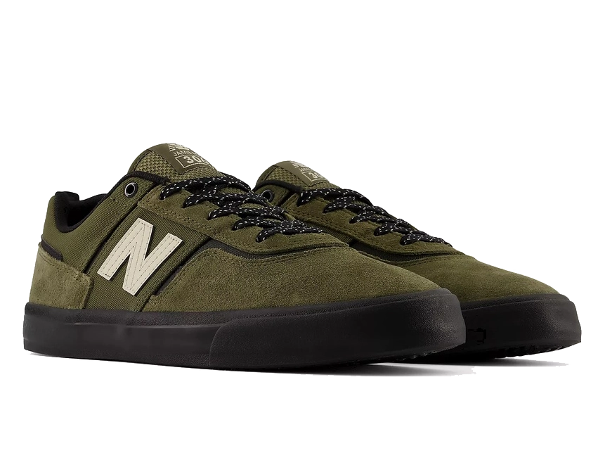 A pair of New Balance low-top skate shoes in olive green suede and mesh, featuring black laces, black soles, and a prominent cream-colored 'N' logo on the side.