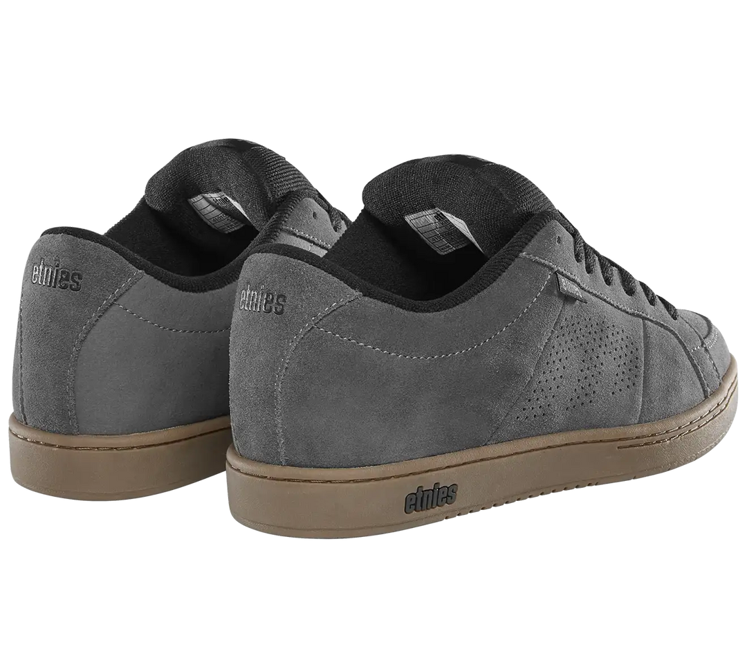 A pair of gray suede sneakers with black laces and a tan gum sole, shown from a three-quarters angle on a white background. The brand name 'elites' is visible on the heel and midsole.
