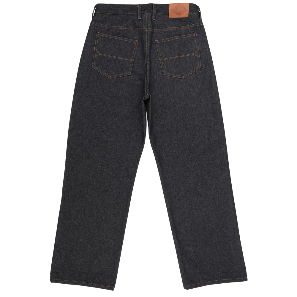 Back view of dark indigo denim jeans with contrast tan stitching and a brown leather patch on the waistband, shown on a plain white background.
