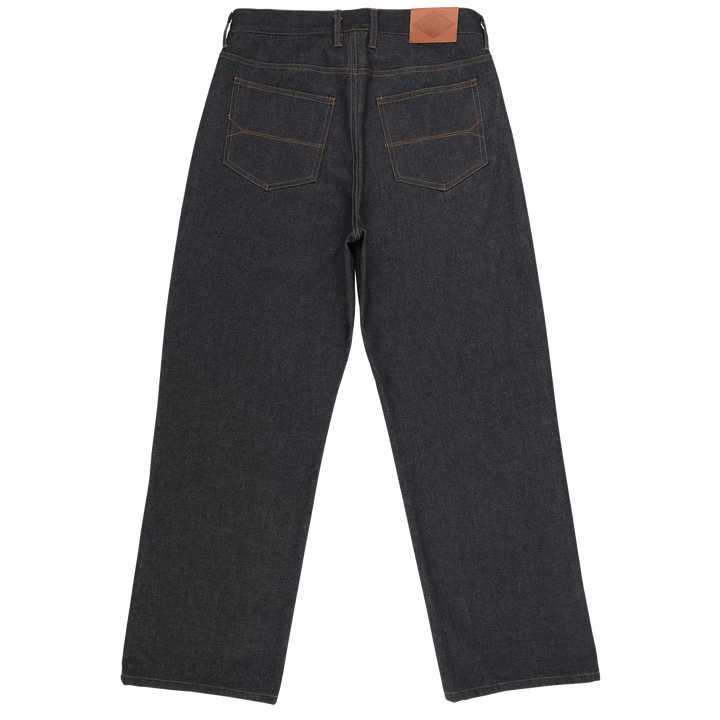 Back view of dark indigo denim jeans with contrast tan stitching and a brown leather patch on the waistband, shown on a plain white background.
