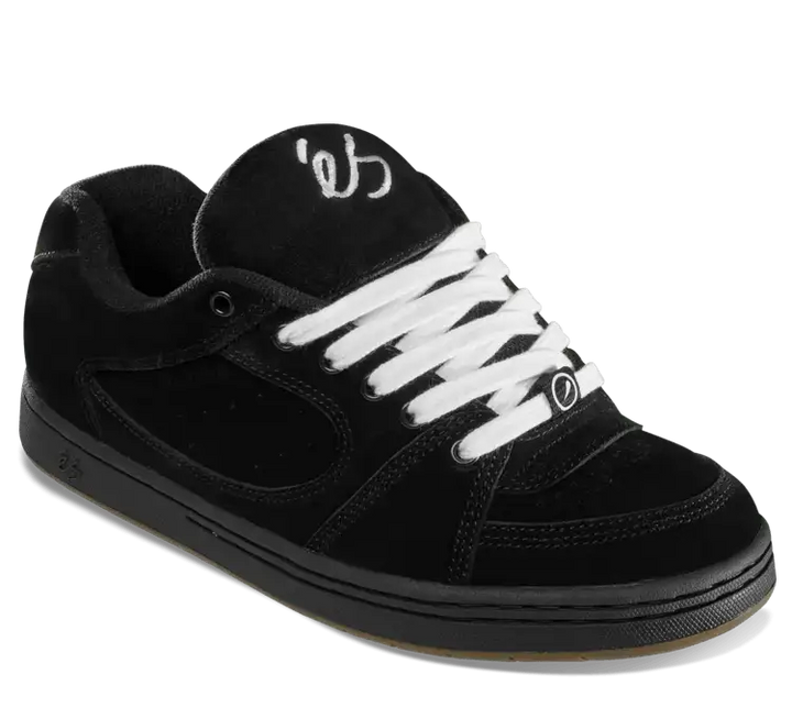 A black suede skate shoe with white laces and a white stylized logo on the tongue, shown from a three-quarters angle on a white background.