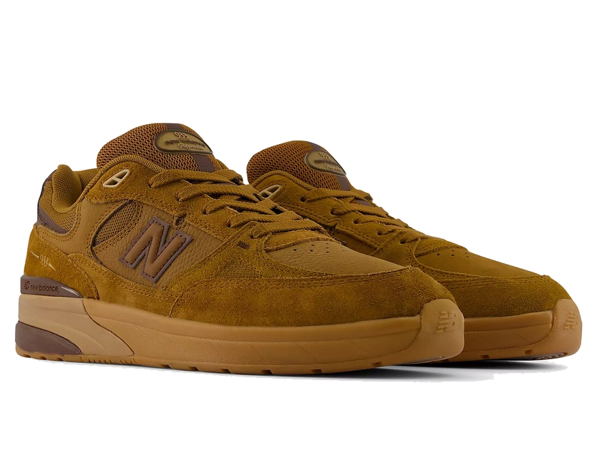 A pair of New Balance 594 sneakers in a monochromatic brown colorway, featuring suede and mesh uppers with matching brown laces, a large 'N' logo on the side, and a thick gum sole.