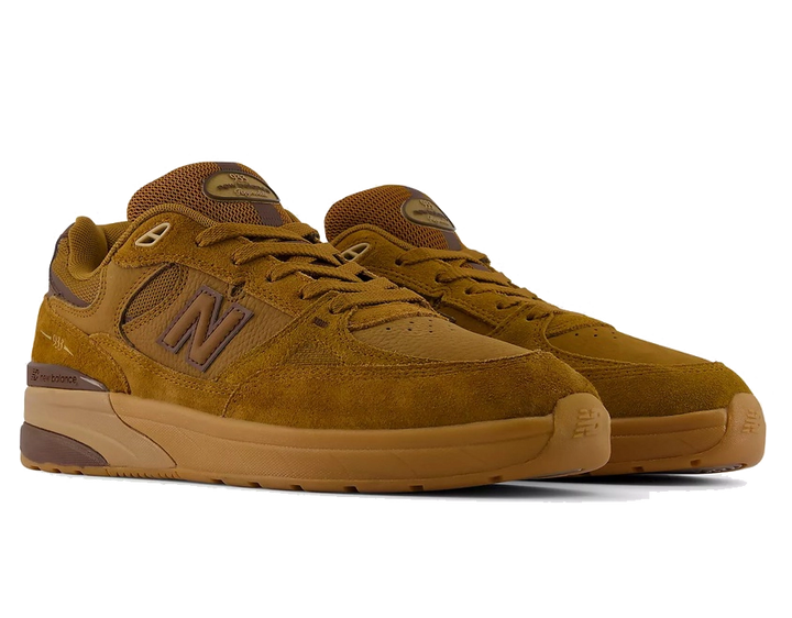 A pair of New Balance 594 sneakers in a monochromatic brown colorway, featuring suede and mesh uppers with matching brown laces, a large 'N' logo on the side, and a thick gum sole.