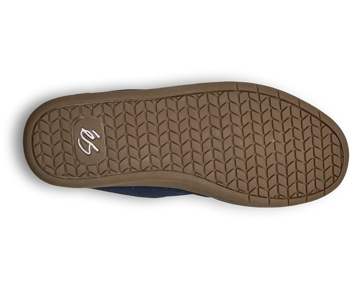 The outsole of a slip-on shoe, showing a brown textured tread pattern with a small white stylized logo in the heel area, photographed on a white background.