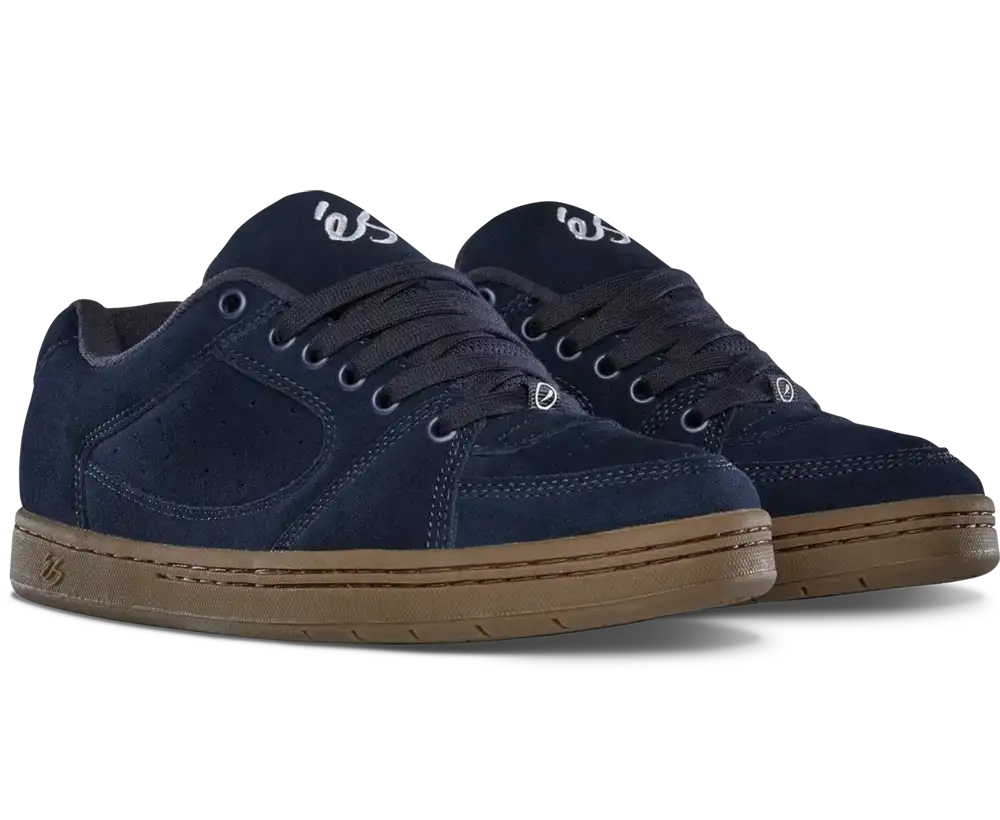A pair of navy blue suede skate shoes with brown gum soles, shown from a three-quarters angle on a white background.