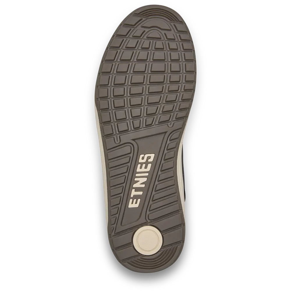Top-down view of a shoe sole showing the textured tread pattern and the embossed brand name 'ETNIES' in beige on a dark brown rubber outsole, with a light beige footbed visible at the heel.