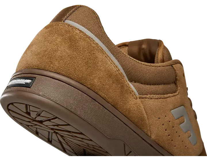 Close-up of a brown suede and canvas sneaker showing the heel, side profile, and textured sole on a white background.