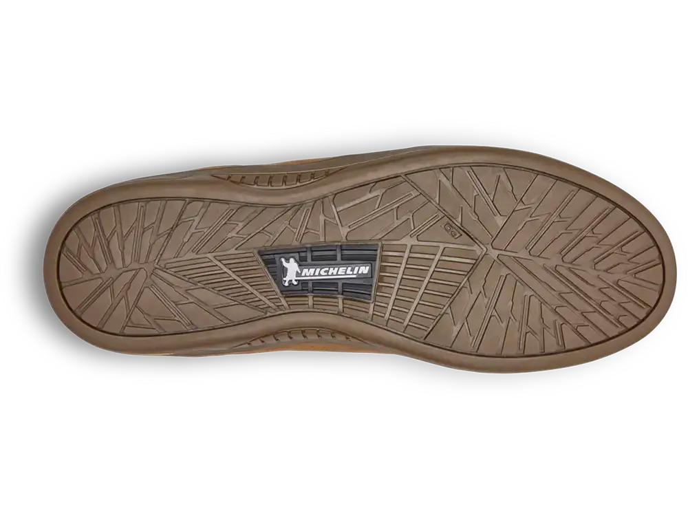 The treaded bottom sole of a brown rubber shoe, featuring a central black and white Michelin logo, shown on a white background with a soft drop shadow.