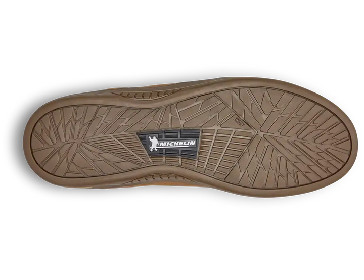 The treaded bottom sole of a brown rubber shoe, featuring a central black and white Michelin logo, shown on a white background with a soft drop shadow.