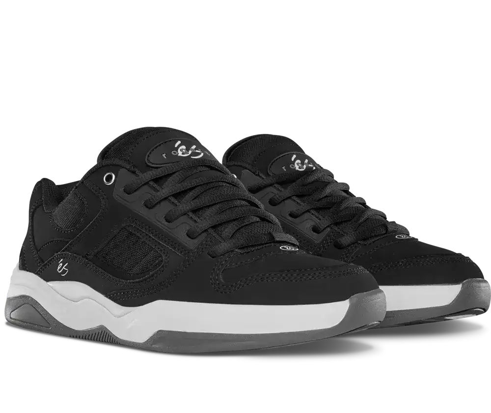 A pair of black low-top sneakers with white midsoles, shown from a three-quarters angle on a white background.