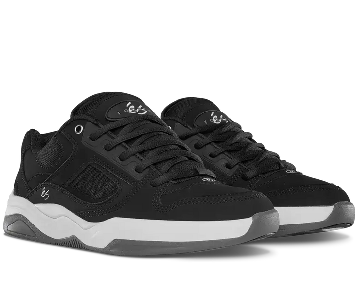 A pair of black low-top sneakers with white midsoles, shown from a three-quarters angle on a white background.