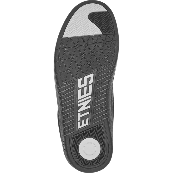 The black and gray outsole of a shoe, featuring the brand name 'ETNIES' in white on the heel, a circular white tread, and a textured gray toe section.