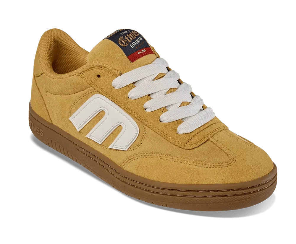 Yellow sneaker with white logo and brown sole on a white background