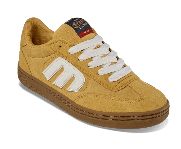 Yellow sneaker with white logo and brown sole on a white background
