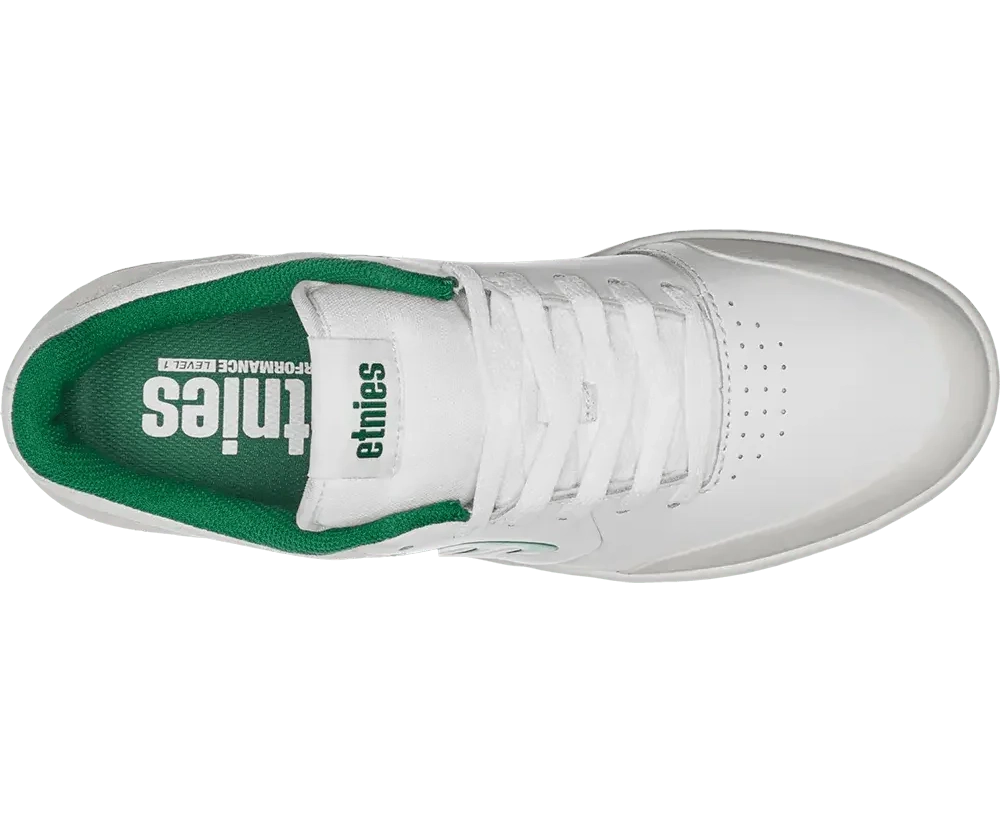 White sneaker with green sole on a white background