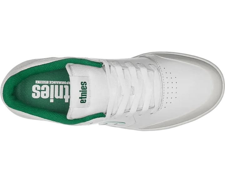 White sneaker with green sole on a white background