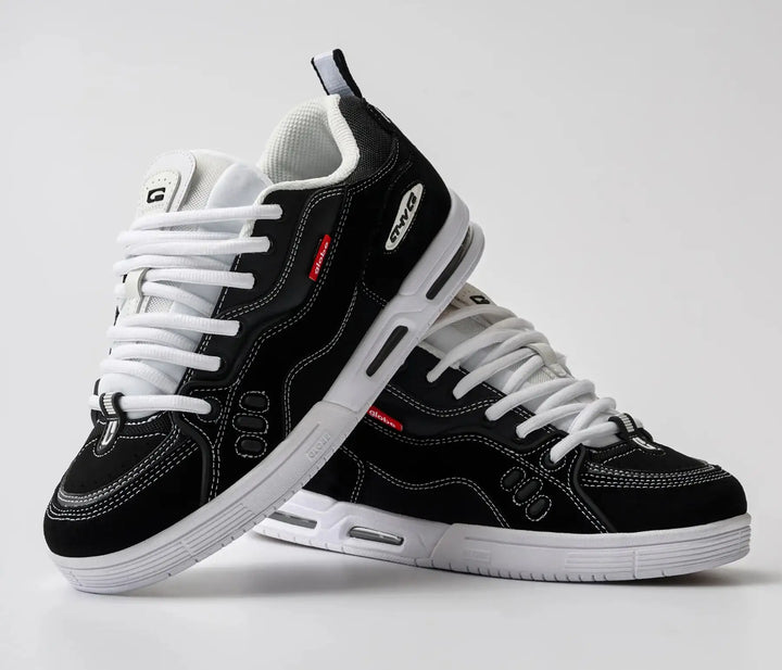 Black and white sneakers with visible branding on a light gray background