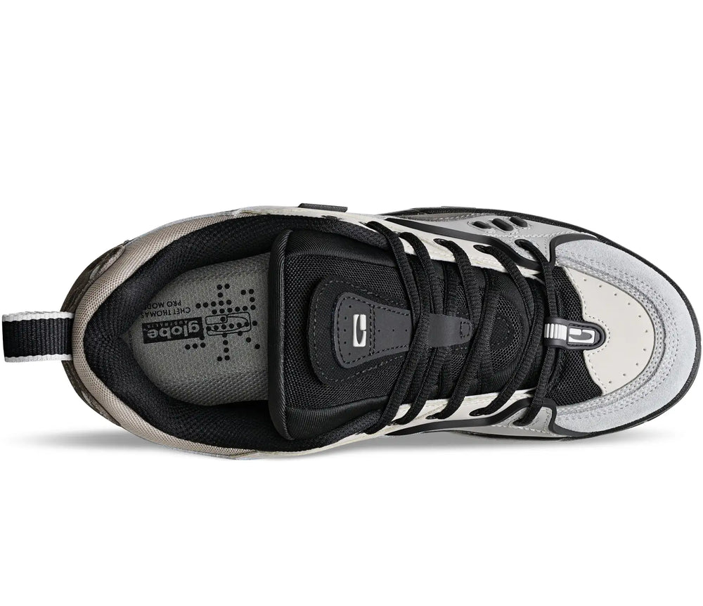 A top-down view of a low-top athletic sneaker in black, gray, and white, featuring a black laces system, a gray textured insole, and a white toe cap.