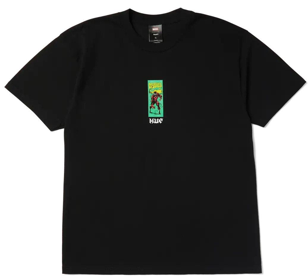 A black short-sleeve crewneck t-shirt featuring a small graphic print on the left chest. The graphic depicts a character in a red outfit against a green background with yellow text, and the word 'HUGO' printed in white below.