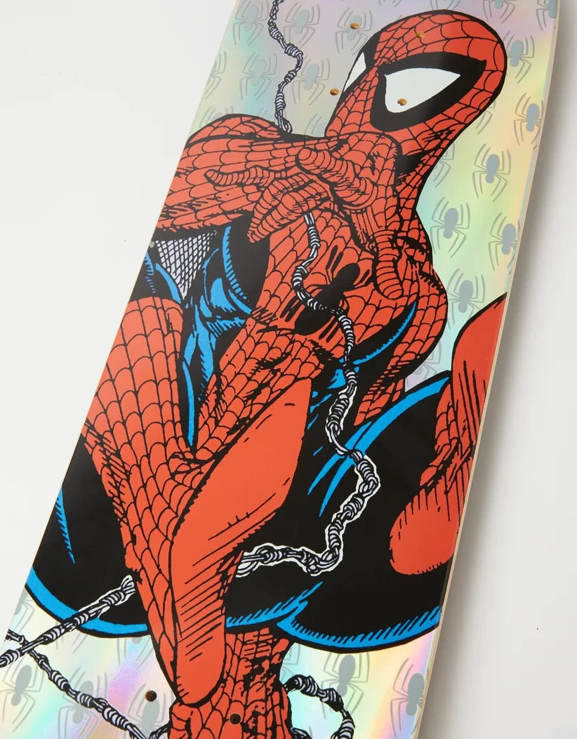 A close-up of a skateboard deck featuring a comic-style Spider-Man graphic on an iridescent holographic background.