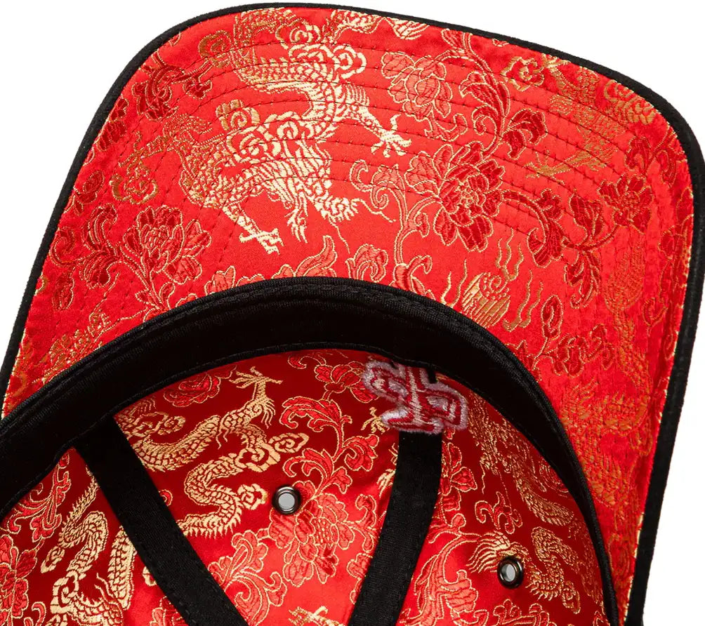Red cap with gold dragon and floral patterns on a white background