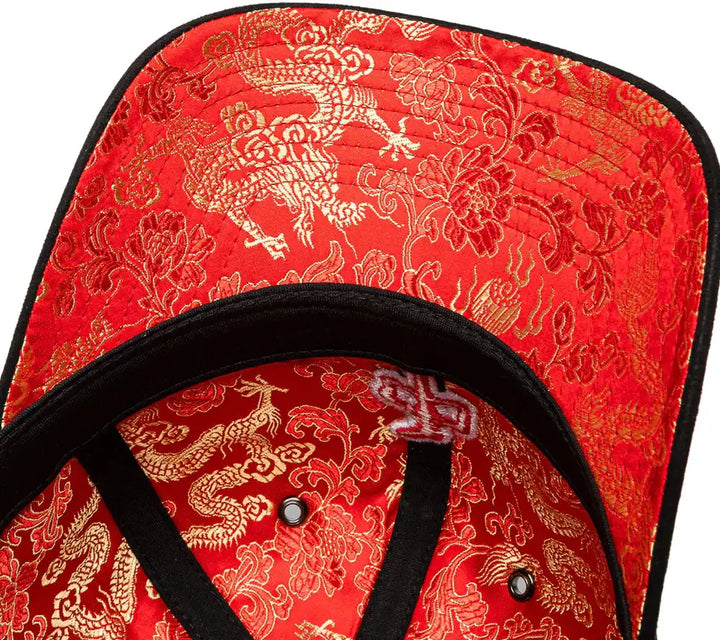 Red cap with gold dragon and floral patterns on a white background