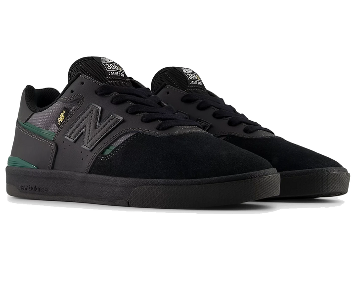 Black sneakers with green accents on a white background