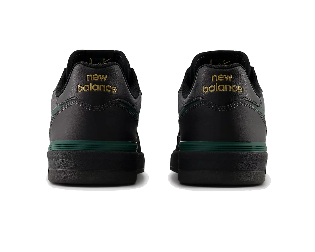 Black New Balance shoes with green accents on a white background
