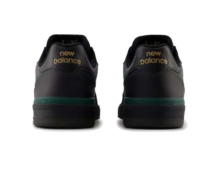 Black New Balance shoes with green accents on a white background