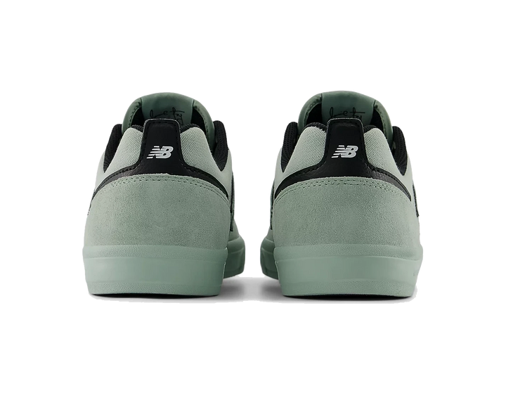 Pair of green sneakers with black accents on a white background