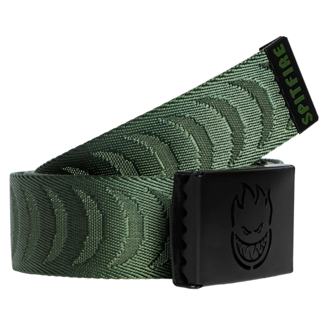 A green patterned web belt with a black metal buckle featuring a stylized face logo, coiled on a white background.