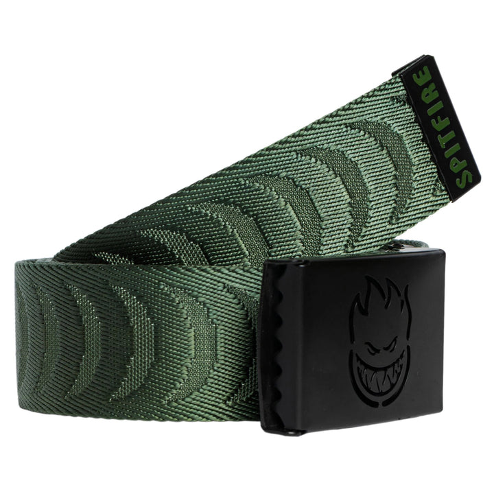A green patterned web belt with a black metal buckle featuring a stylized face logo, coiled on a white background.