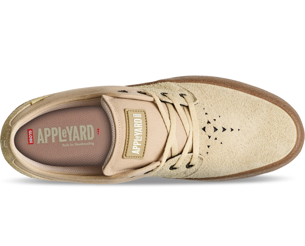 A single Appleyard skate shoe in beige suede and tan canvas, featuring black laces, black triangular cutouts on the side, and a brown gum sole, shown from a top-down view on a white background.